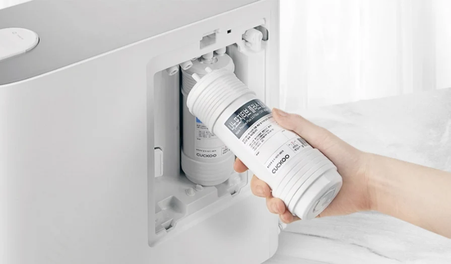 CUCKOO TN100 water purifier with a hand replacing or inserting the internal water filter cartridge. (CP-TN100)